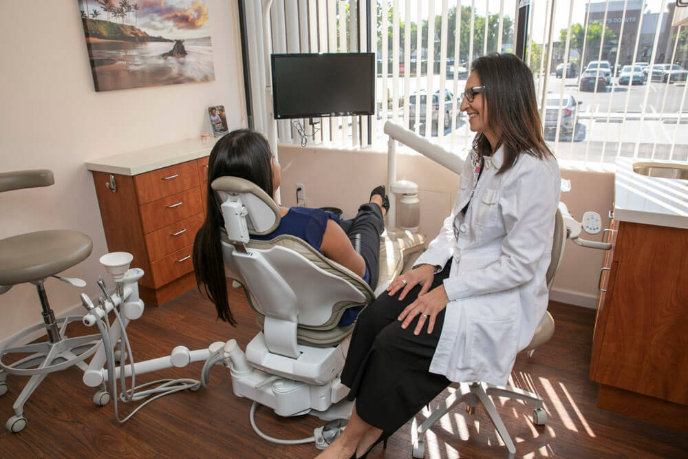 Dr. Maha Boulos of South Bay Dental Smiles talking with patient in dental chair